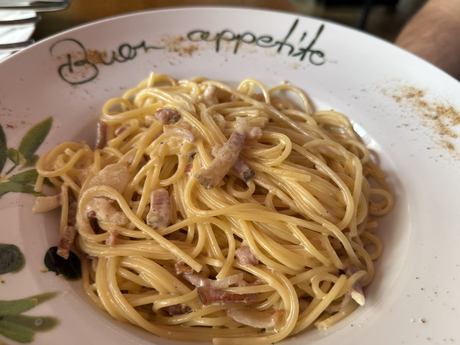 Spaghetti Carbonara mit Speck auf einem Teller mit der Aufschrift Buon appetito